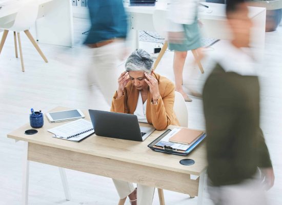 Busy office, stress and senior woman with headache, crisis or vertigo while working on a laptop. Co.
