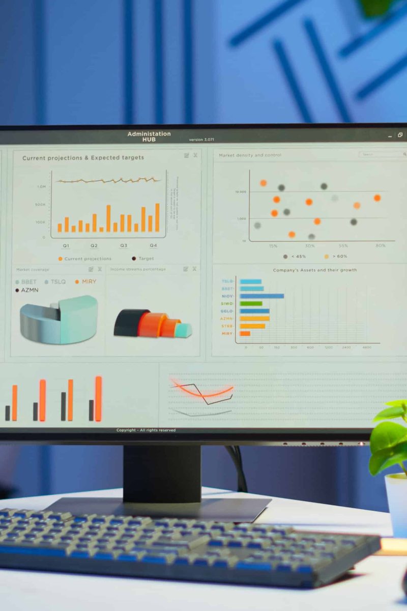 Interior of empty start up business office with modern design during night with graphics running on the desktop. Financial company with nobody in it, place of work startup, workplace indoors concept
